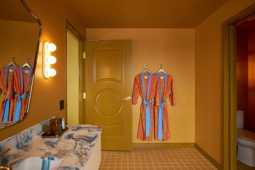 a bathroom with two mannequins in front of a door at Hotel Genevieve in Louisville