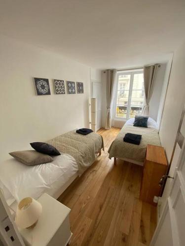 une chambre avec deux lits et une fenêtre dans l'établissement Coeur de Versailles Notre Dame - 3 pièces, à Versailles