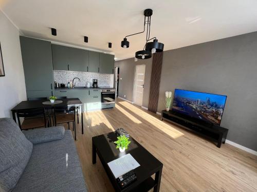 sala de estar con sofá y TV y cocina en Vert House Katowice en Katowice