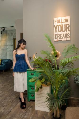 a woman is standing next to a green dresser at Oceanus Oasis Retreat - Nha Trang Apartment in Nha Trang