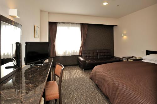 um quarto de hotel com uma cama e um sofá em Matsuzaka Frex Hotel em Matsuzaka