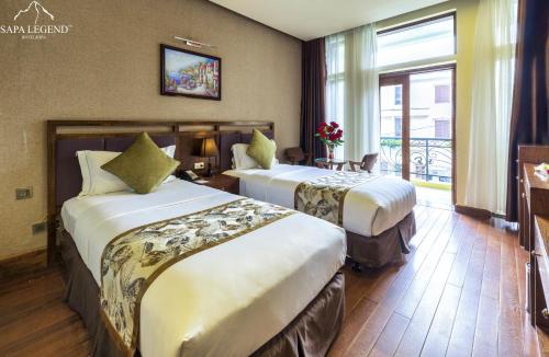 Habitación de hotel con 2 camas y ventana en Sapa Legend Hotel & Spa, en Sa Pa