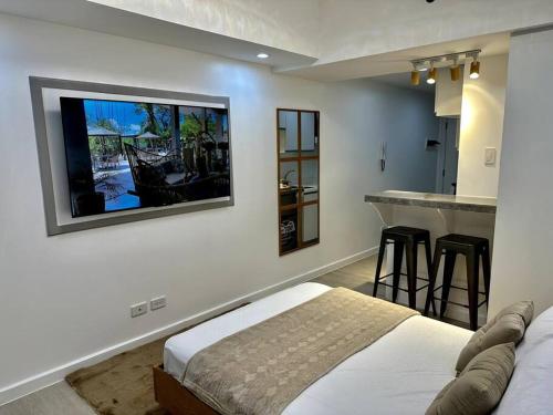 a bedroom with a bed and a kitchen with a bar at Adjacent studio (023) in San Fernando