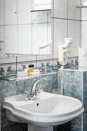 a bathroom with a sink and a mirror at Hotel Imparatul Romanilor Hotel & SPA in Sibiu