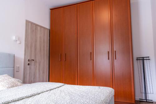 a bedroom with a large wooden cabinet next to a bed at Apartment Ivana Krško in Krško