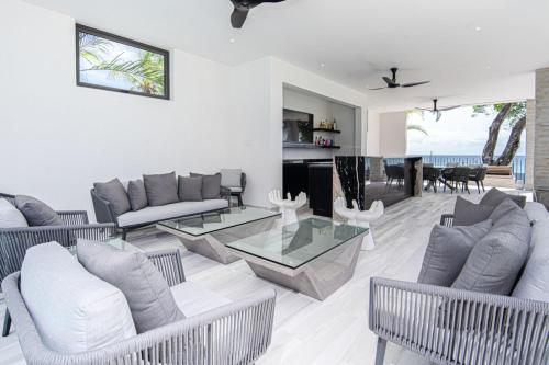 Una sala de estar con muebles blancos y vista al mar. en Onyx by Blue Sky Luxury, en Saint James