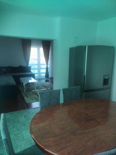 a dining room table with chairs and a refrigerator at Apartments Amina Sarajevo in Sarajevo