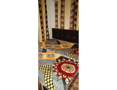 a bed with a quilt on top of it at Hotel Dayban Resort, Pahalgam in Pahalgām