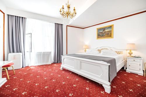 una camera con un letto bianco e un tappeto rosso di Hotel Imparatul Romanilor a Sibiu