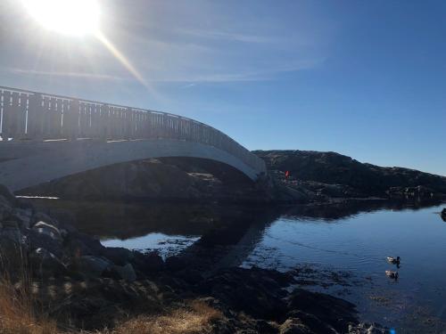 a bridge over a river with the sun shining on it at Brightside Apartment in Kristiansand