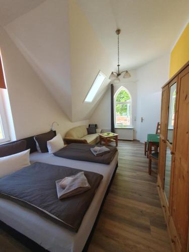 a bedroom with two beds and a table and a window at Twee Linden Warnemünde Zentrum in Warnemünde