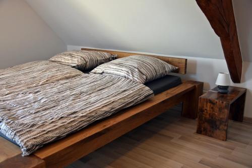 a bed with two pillows on it with a table at Ferienwohnungen Straußenfarm Burkhardt in Schmölln