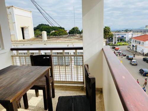 a balcony with a wooden table and a view of a street at Imbasa House - Arusha in Arusha