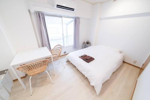 a bedroom with a bed and a desk and a window at Takadanobaba Address102 in Tokyo