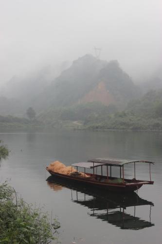 two boats on the water with mountains in the background at Halo Retreat in Hòa Bình