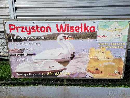 a sign with a swan on the side of a building at Apartamenty Promyk Wisełka in Wisełka