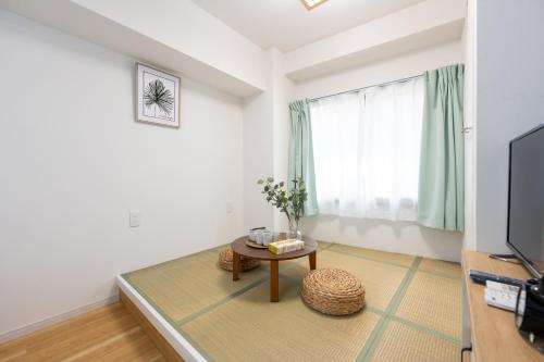 a living room with a table and a television at 今和Hotel in Tokyo