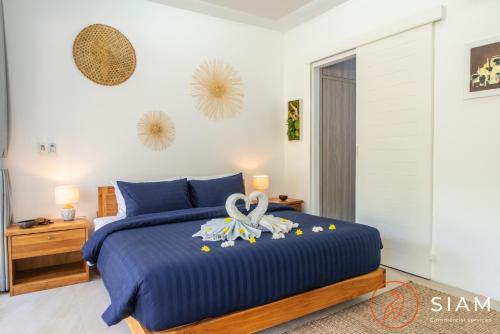 a bedroom with a blue bed with a towel on it at Villa Sumalee 3Br Private Pool in Koh Samui 