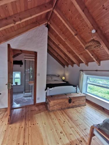 a bedroom with a bed and a wooden floor at Keadue Holiday Cottage in Burtonport