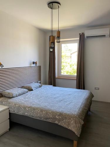 a bedroom with a large bed and a window at Sandra's House in Izola