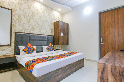 a bedroom with a large bed and a wooden door at FabHotel Prime Taj Castle in Amritsar