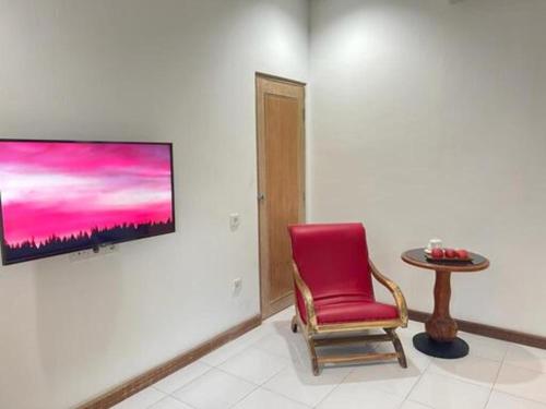 a red chair and a table in a room at Lubdhaka Canggu in Canggu