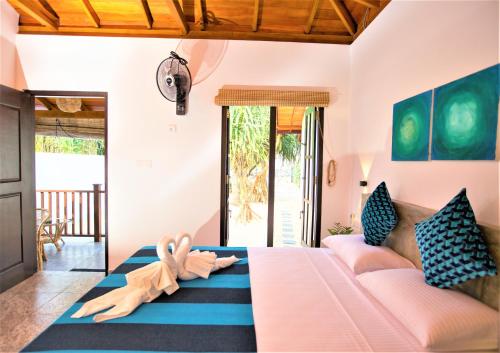 un soggiorno con letto e divano di Sea Shell Villa Hikkaduwa 2 Separate Cabanas Ocean Front Villa a Hikkaduwa