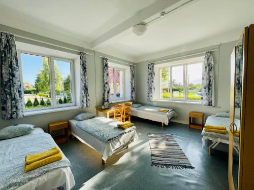 a bedroom with two beds and two windows at Endla Hostel ja Apartamendid in Haapsalu