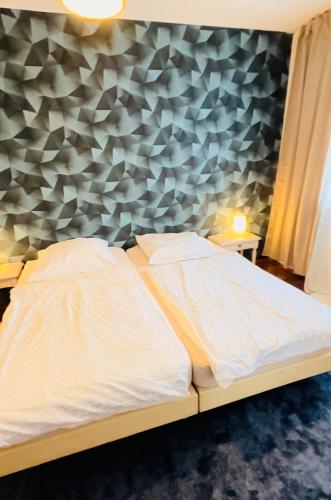 ライプツィヒにあるFeWo Auenblickの幾何学的な壁のベッドルームのベッド1台