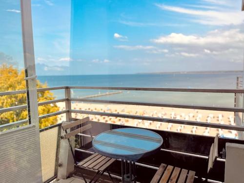 a balcony with a table and chairs and the beach at Penthaus Horizont mit Meerblick in Lübeck