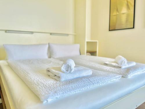 a white bed with towels on top of it at Penthaus Horizont mit Meerblick in Lübeck