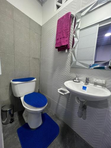 a bathroom with a toilet and a sink at Hostal Queens Deluxe in Florencia