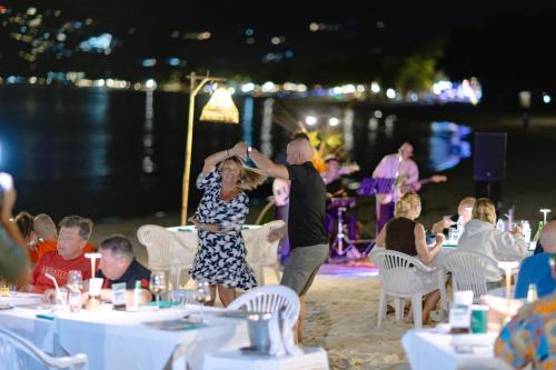a man and woman dancing at a party on the beach at Baan Chaweng Beach Resort & Spa - SHA Extra Plus in Chaweng