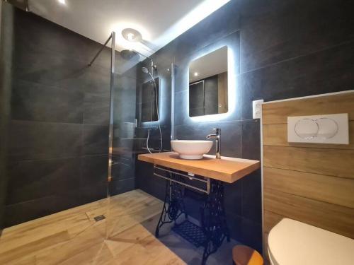 a bathroom with a sink and a glass shower at Chalet Victorine, vue imprenable avec spa in Gérardmer