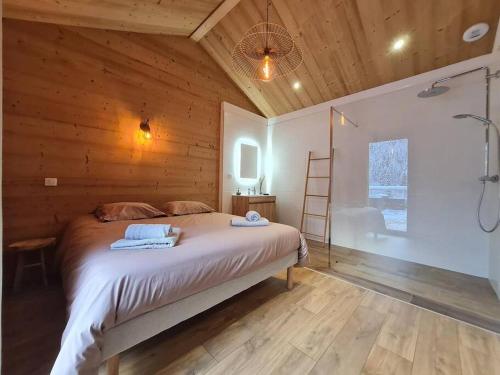 a bedroom with a bed and a bathroom with a shower at Chalet Victorine, vue imprenable avec spa in Gérardmer