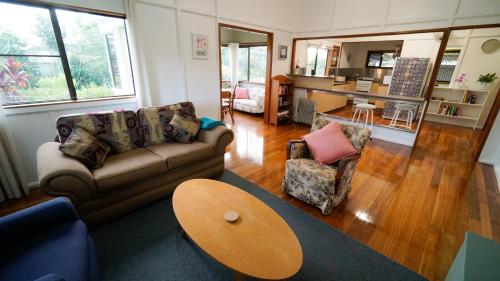 a living room with a couch and chairs and a table at Jindy's Cottage Atherton in Atherton
