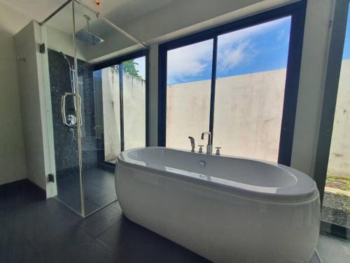 a large bathroom with a tub and a large window at Blu Village Pool Villa in Bang Tao Beach