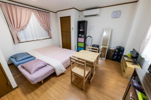 a small bedroom with a bed and a table at ヴァンベール晃永2 in Tokyo