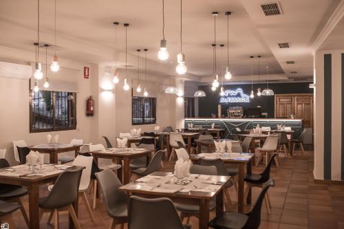 un restaurante con mesas y sillas y un bar en Hostal Altamira Guadalupe, en Guadalupe