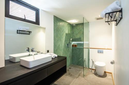 a bathroom with a sink and a glass shower at Lofty Nyc Vibes 200m To Canggu Beach in Canggu