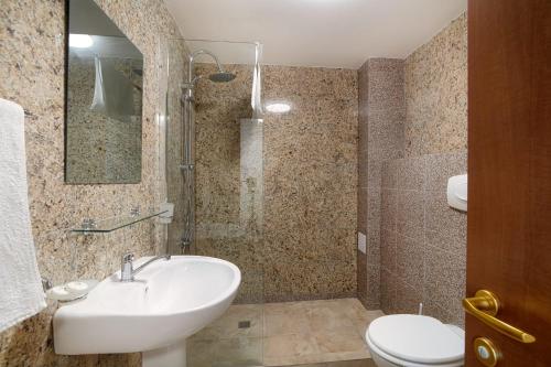 a bathroom with a sink and a toilet at Amore Resort in Băltenii de Sus