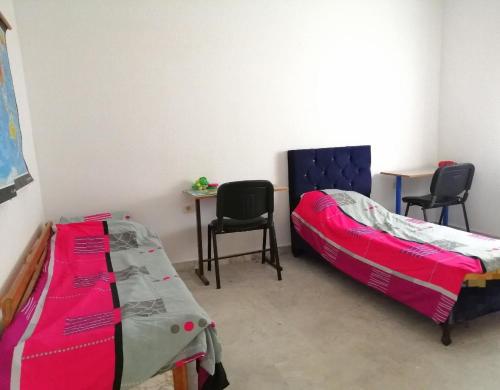 1 Schlafzimmer mit 2 Betten, einem Tisch und Stühlen in der Unterkunft JasminVilla in Sousse