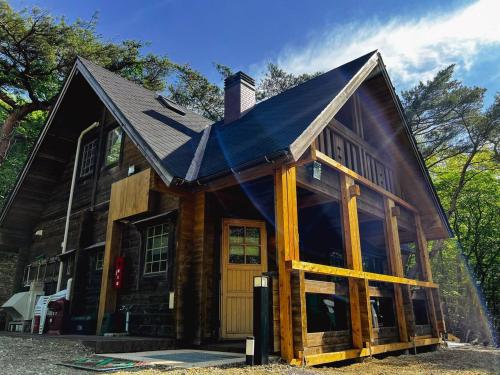 a log cabin with a gambrel roof at 那須高原山小屋 in Nasu