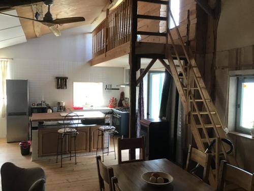 une cuisine avec un escalier en bois et une table dans une chambre dans l'établissement ladavaminne, à Chérier