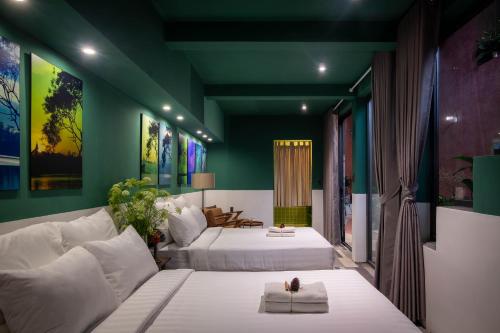 two beds in a room with green walls at The Note Dalat in Da Lat