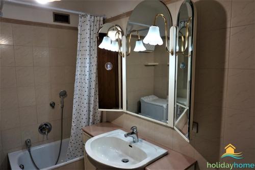 een badkamer met een wastafel, een spiegel en een bad bij Lake Garda Home in Riva del Garda