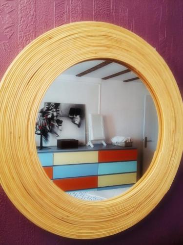 a mirror on a wall with a colorful room at LE CERISIER in Sivry-Courtry