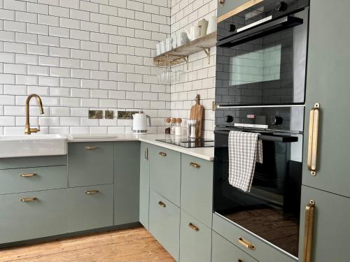 a kitchen with a sink and a stove at The Old Tearoom At Ty Llywelyn By Birch Stays in Conwy