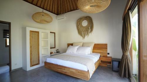 a bedroom with a large bed with white sheets at petra bianca uluwatu in Uluwatu