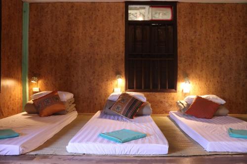 Cette chambre comprend 2 lits et une fenêtre. dans l'établissement Homestay in Da Bia - Community Based Tourism, à Hòa Bình